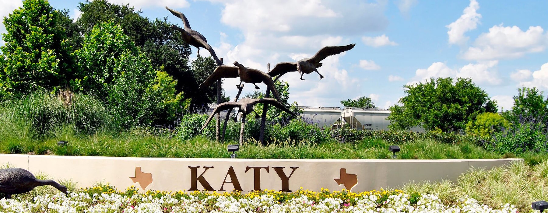 a statue with a sign and trees