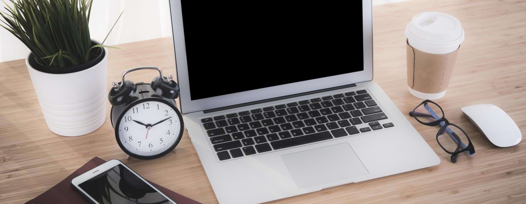a laptop and a watch on a table
